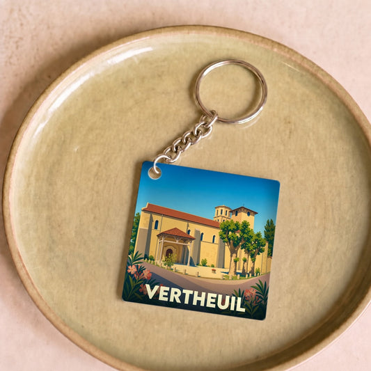 Porte-clés souvenir de la ville de Vertheuil avec une illustration stylisée de son abbaye.