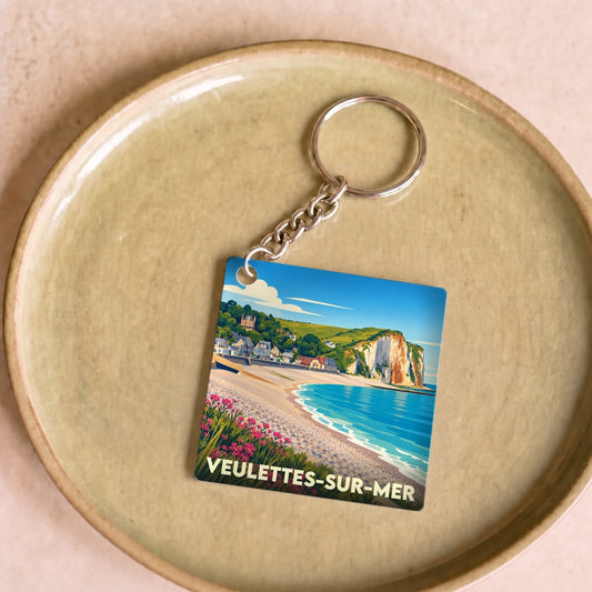 Porte-clés souvenir de Veulettes-sur-Mer avec une illustration stylisée de sa plage et de ses falaises.