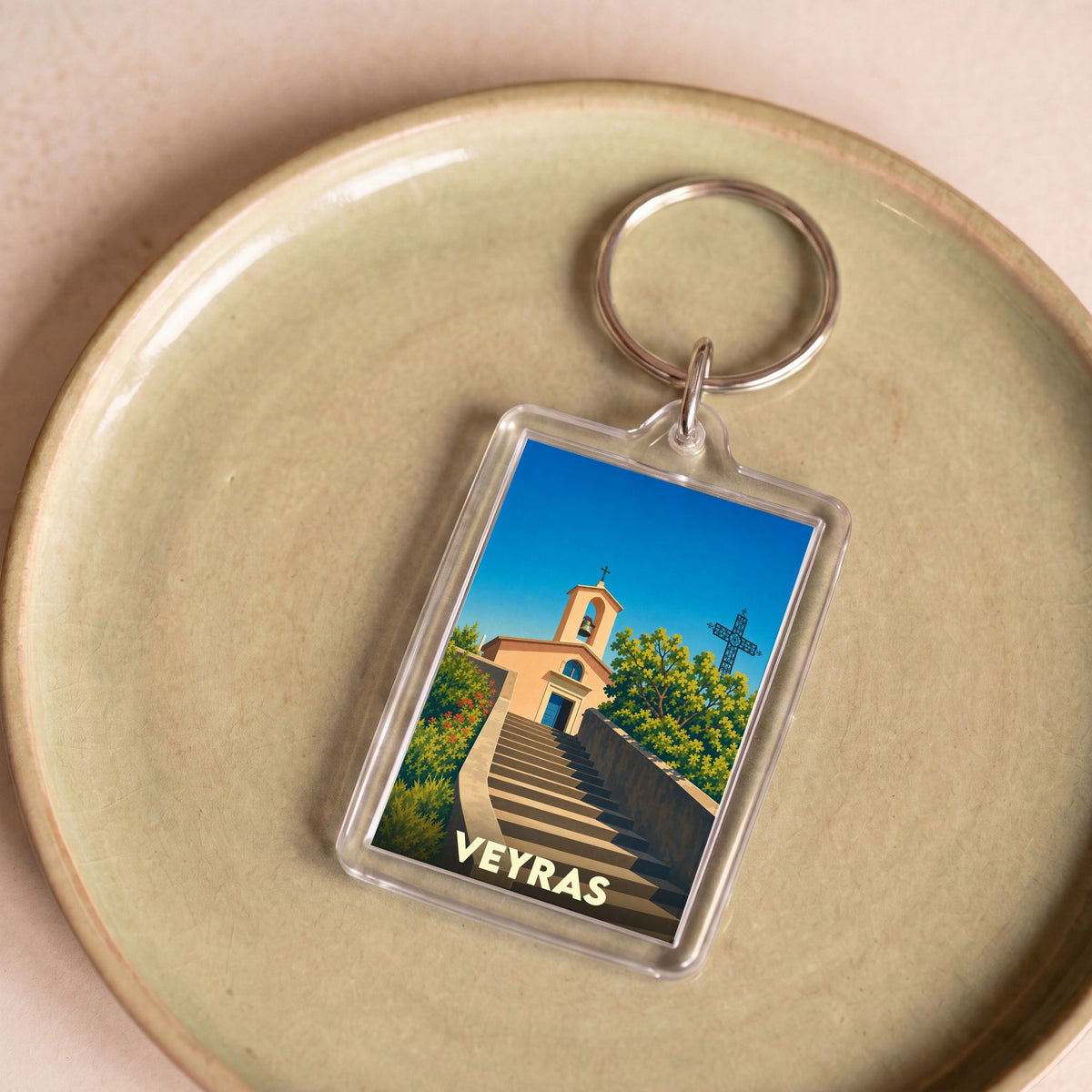 Porte-clés souvenir de la ville de Veyras avec une illustration stylisée d'une église et de son escalier.