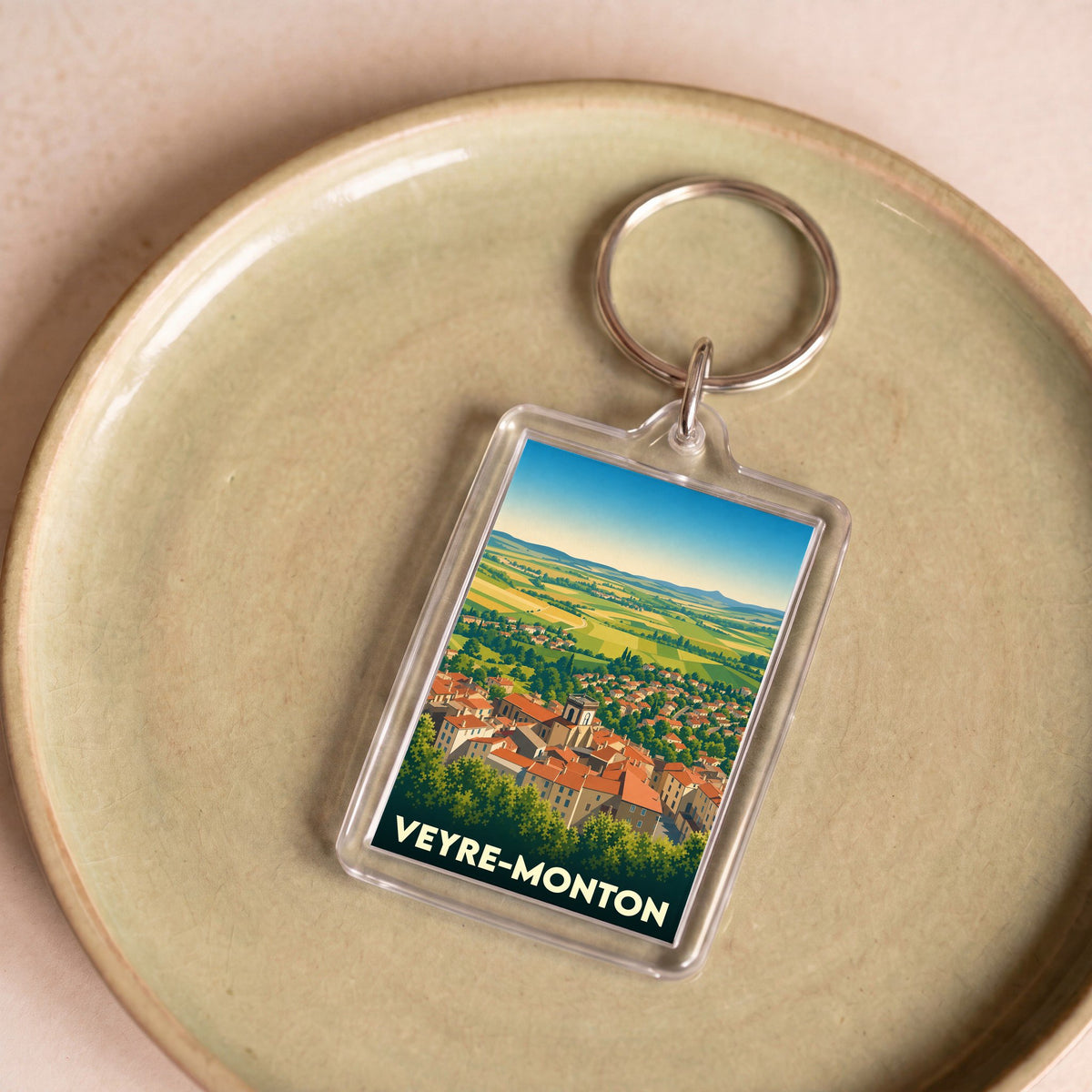 Porte-clés souvenir de la ville de Veyre-Monton avec une illustration panoramique stylisée.