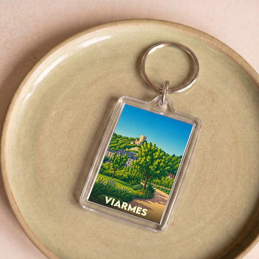 Porte-clés souvenir de la ville de Viarmes avec une illustration colorée et stylisée d'un paysage local.