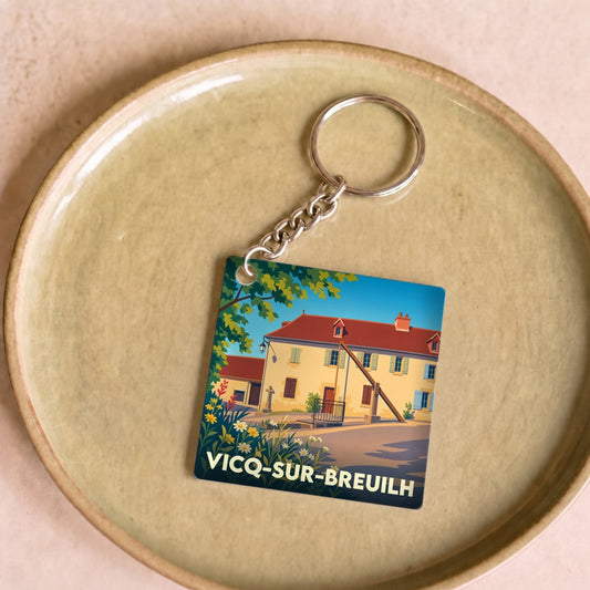 Porte-clés souvenir de la ville de Vicq-sur-Breuilh avec une illustration stylisée de son patrimoine local.
