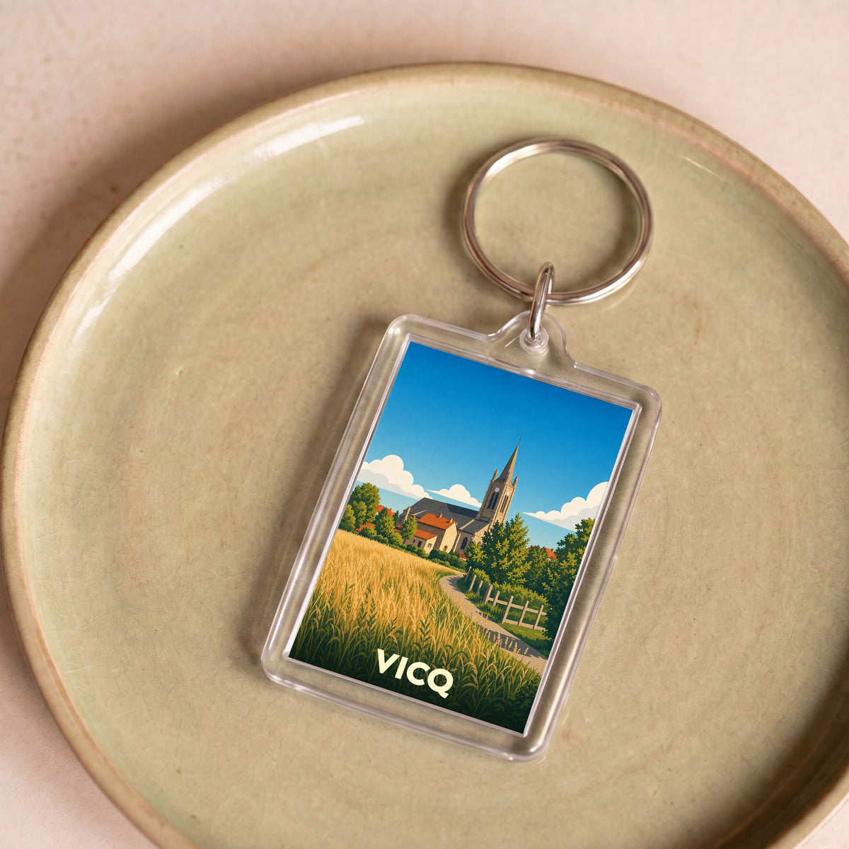 Porte-clés souvenir de la ville de Vicq avec une illustration stylisée.