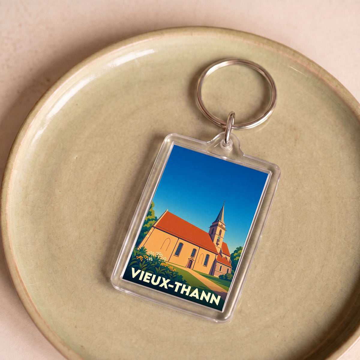 Porte-clés souvenir de la ville de Vieux-Thann avec une illustration stylisée de son église.