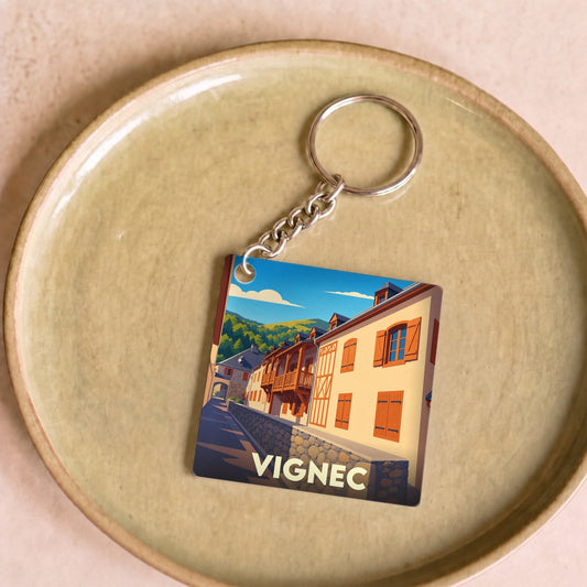 Porte-clés souvenir de la ville de Vignec avec une illustration stylisée de ses façades traditionnelles.