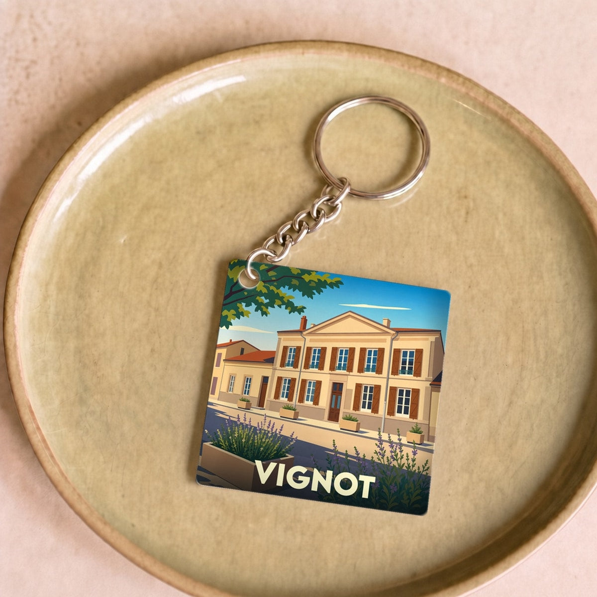 Porte-clés souvenir de la ville de Vignot avec une illustration stylisée.