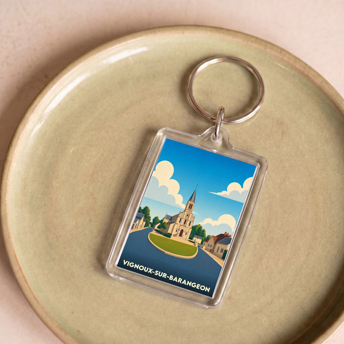 Porte-clés souvenir de la ville de Vignoux-sur-Barangeon avec une illustration stylisée de son église.