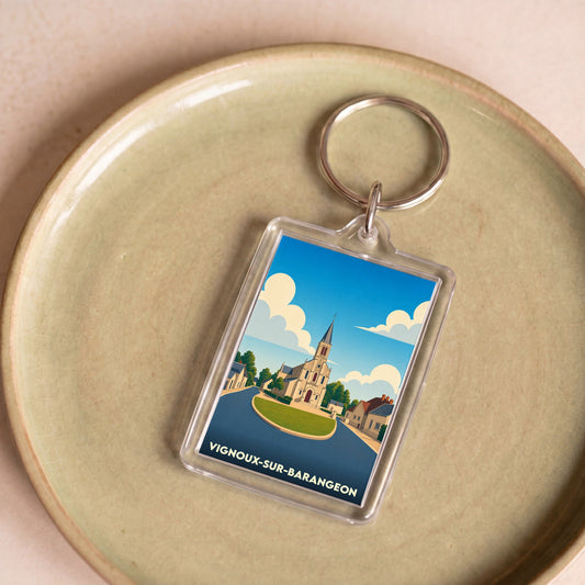 Porte-clés souvenir de la ville de Vignoux-sur-Barangeon avec une illustration stylisée de son église.