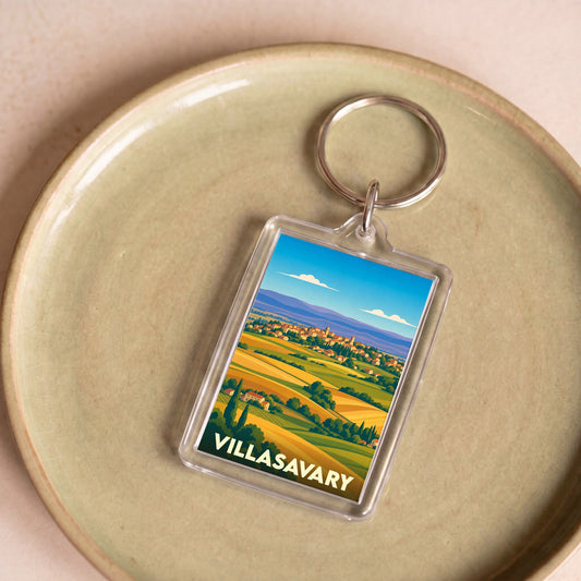 Porte-clés souvenir de la ville de Villasavary avec une illustration stylisée de paysages vallonnés.