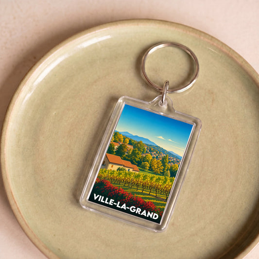 Porte-clés souvenir de la ville de Ville-la-Grand avec une illustration colorée de son paysage.