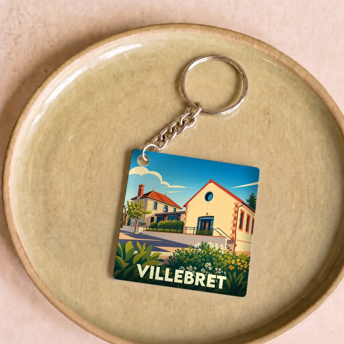 Porte-clés souvenir de la ville de Villebret avec une illustration stylisée.