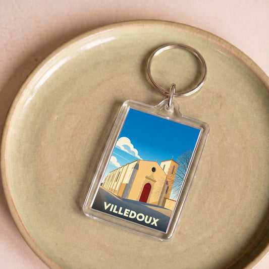 Porte-clés souvenir de la ville de Villedoux avec une illustration stylisée de son église.