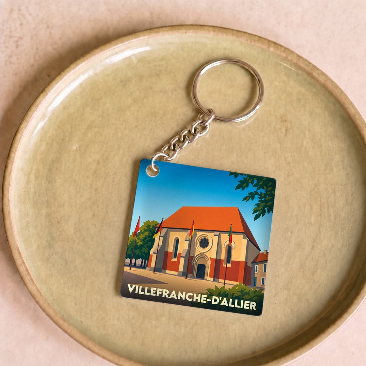 Porte-clés souvenir de la ville de Villefranche-d'Allier avec une illustration stylisée de son église.