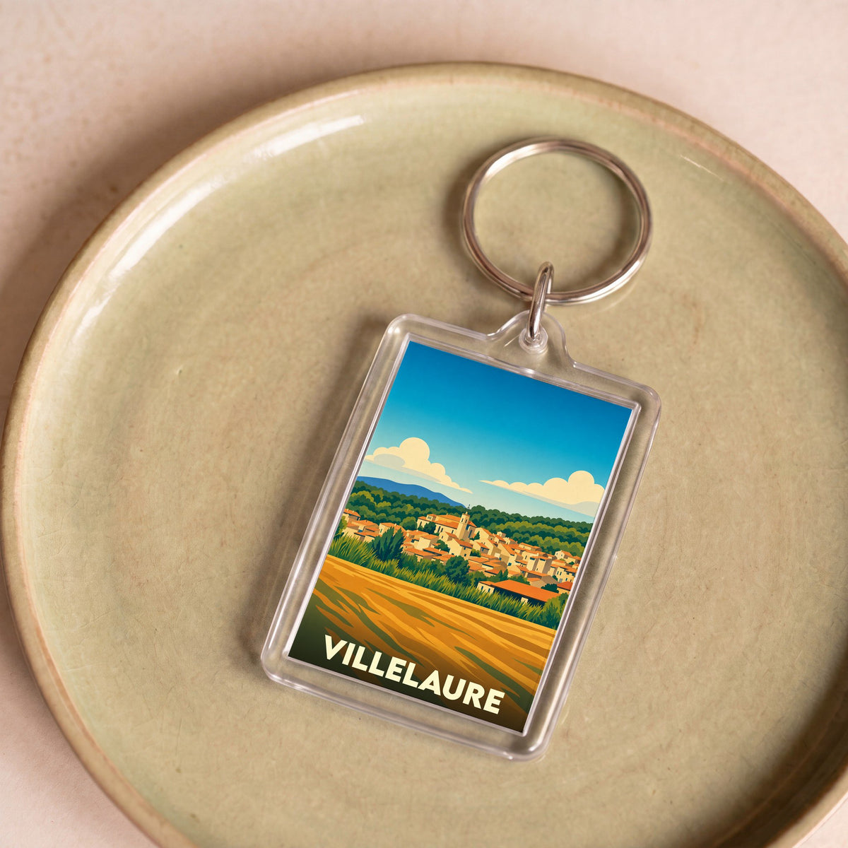 Porte-clés souvenir de la ville de Villelaure avec une illustration stylisée de son paysage provençal.