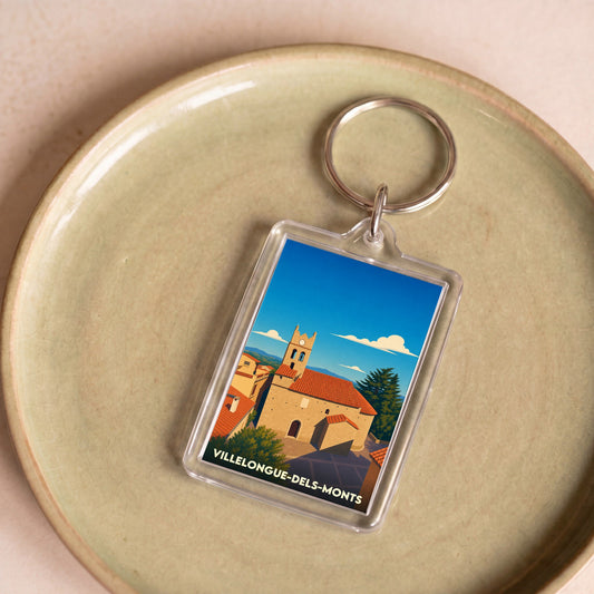 Porte-clés souvenir de la ville de Villelongue-dels-Monts avec une illustration stylisée de son église.