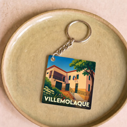 Porte-clés souvenir de la ville de Villemolaque avec une illustration stylisée de sa mairie.