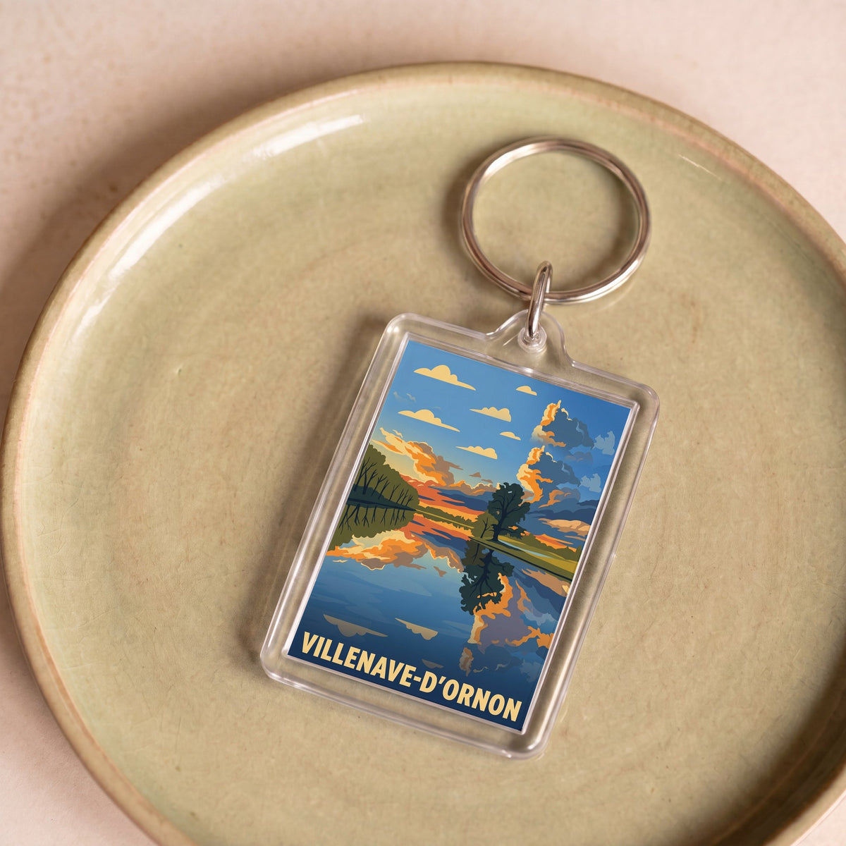 Porte-clés souvenir de la ville de Villenave-d'Ornon avec une illustration stylisée d'un paysage.