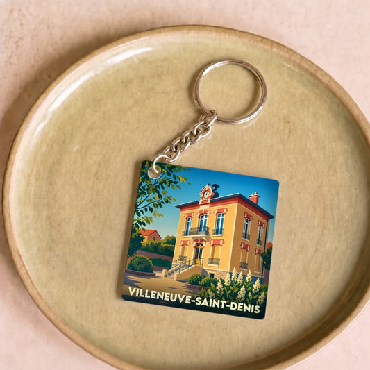 Porte-clés souvenir de la ville de Villeneuve-Saint-Denis avec une illustration colorée et stylisée.