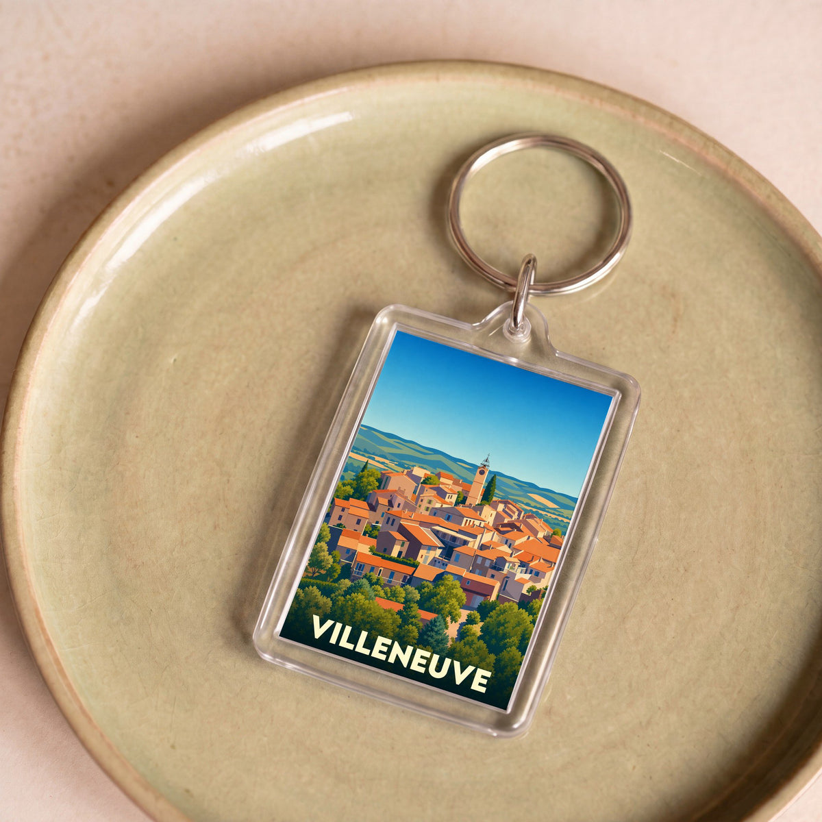 Porte-clés souvenir de la ville de Villeneuve avec une illustration stylisée de ses toits orangés.