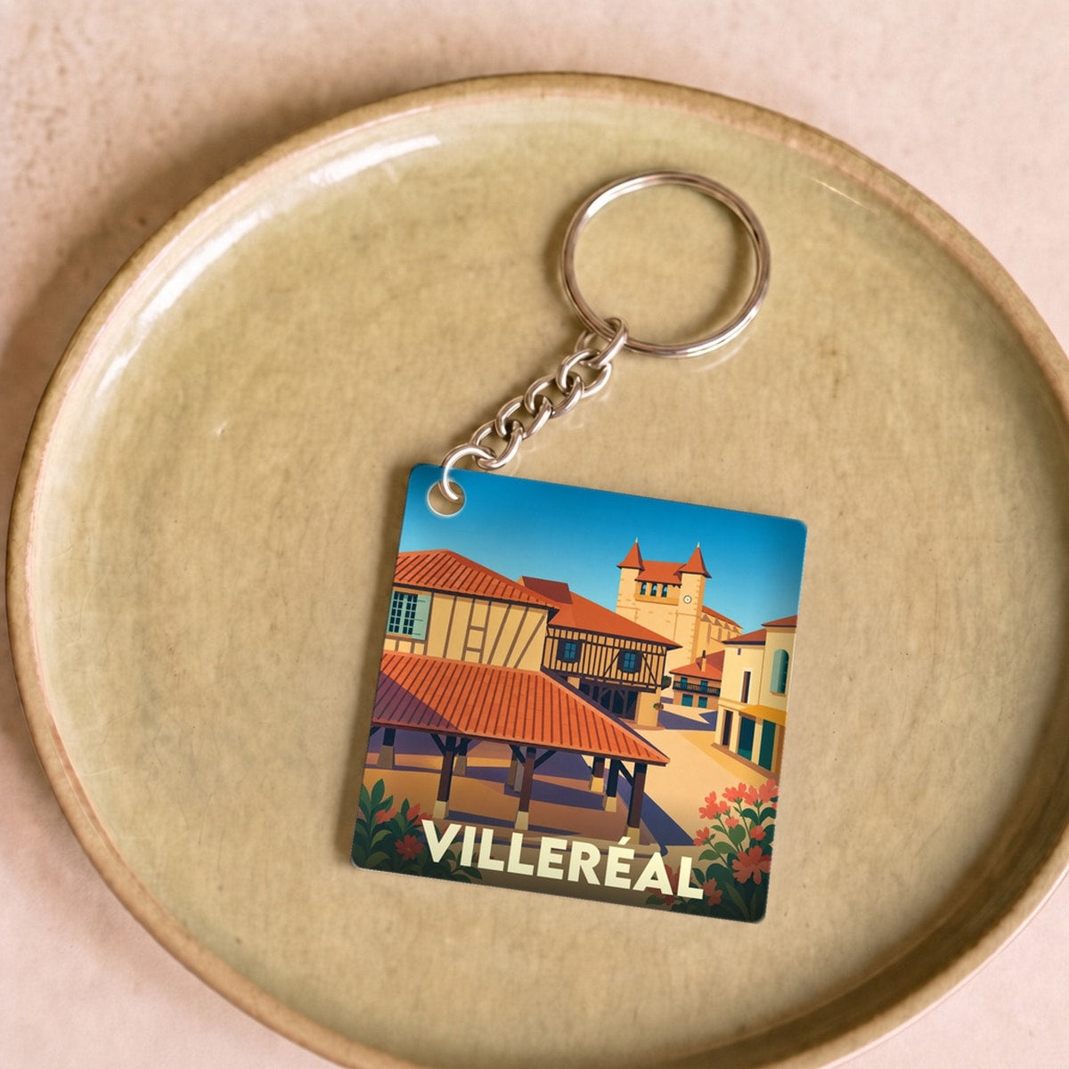 Porte-clés souvenir de la ville de Villeréal avec une illustration stylisée de sa halle et de son église.