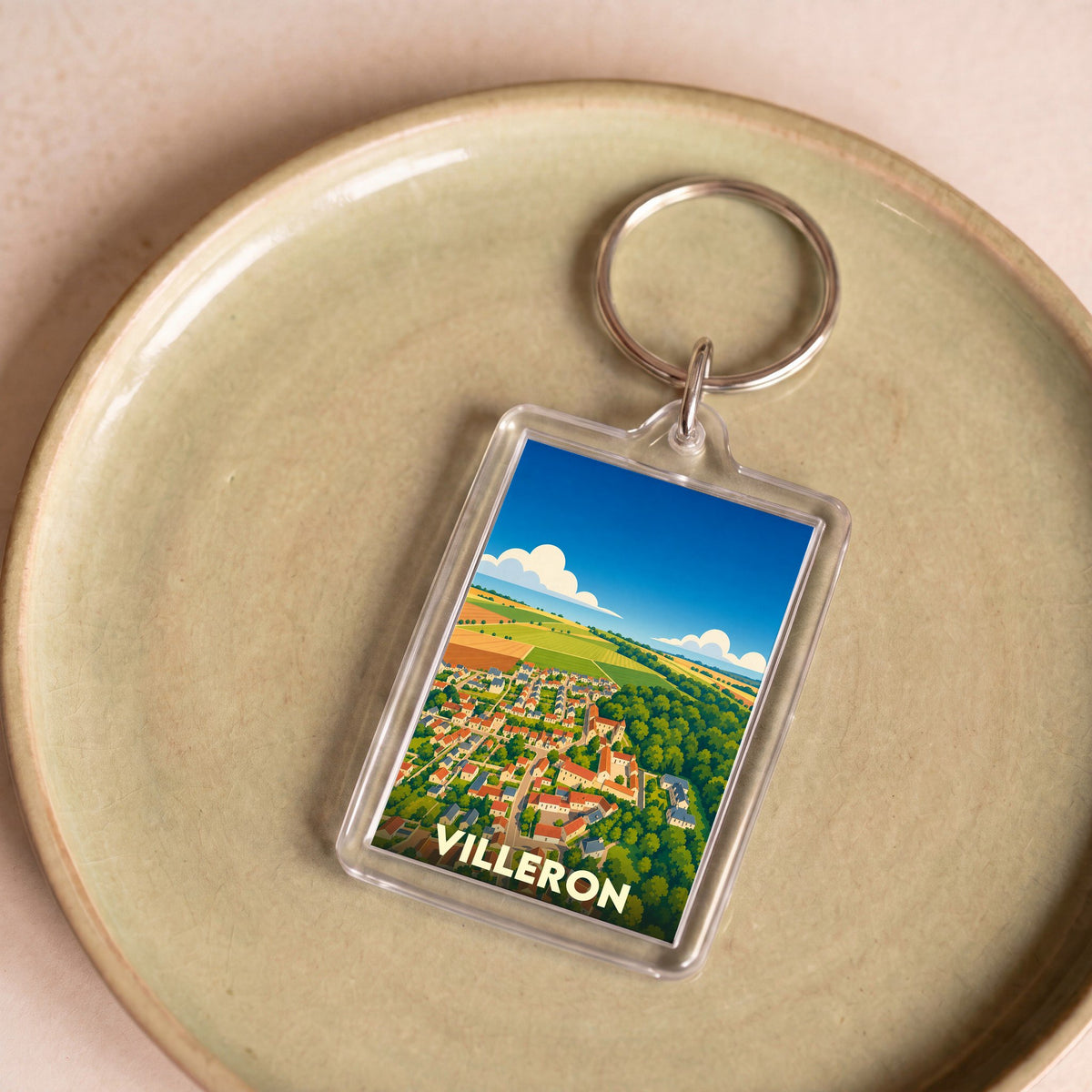 Porte-clés souvenir de la ville de Villeron avec une illustration stylisée vue du ciel.