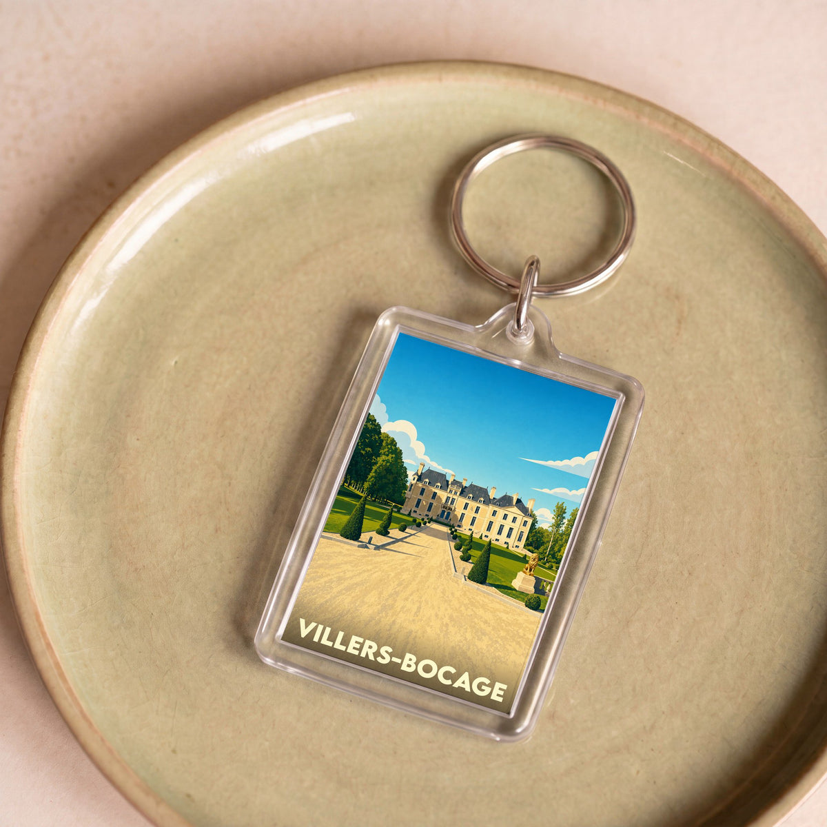 Porte-clés souvenir de la ville de Villers-Bocage avec une illustration stylisée d'un château.