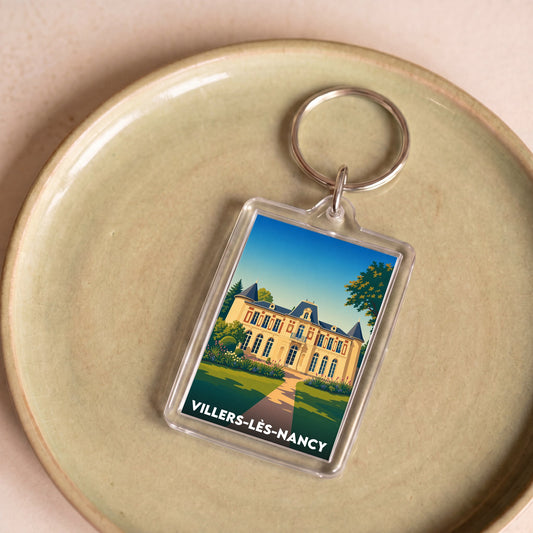 Porte-clés souvenir de la ville de Villers-lès-Nancy avec une illustration stylisée.