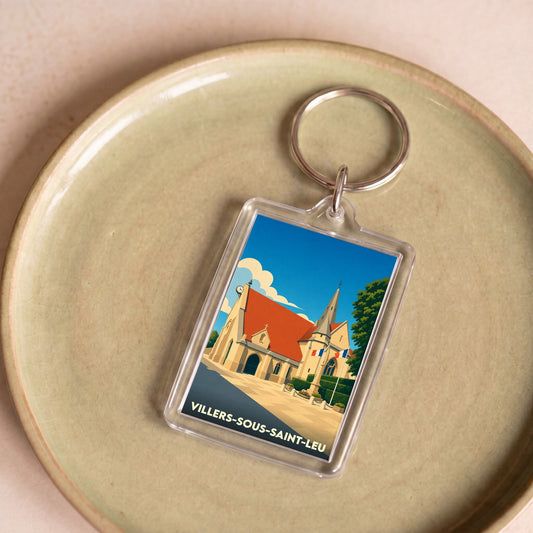 Porte-clés souvenir de Villers-sous-Saint-Leu présentant une illustration stylisée de son église sous un ciel bleu.