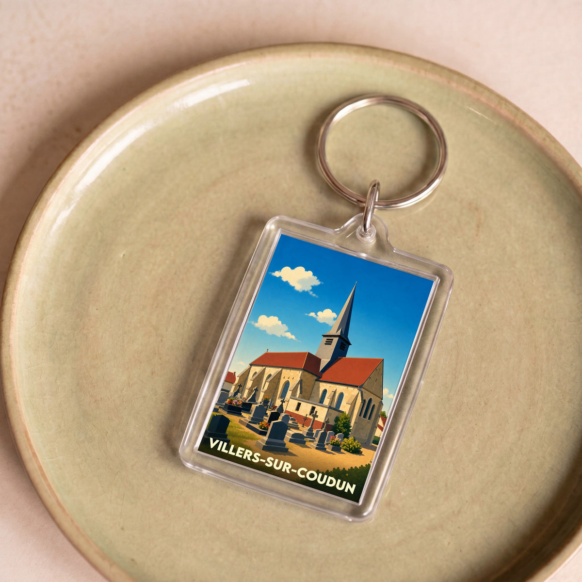 Porte-clés souvenir de la ville de Villers-sur-Coudun avec une illustration stylisée de son église.
