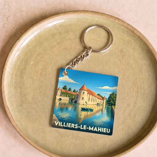 Porte-clés souvenir de la ville de Villiers-le-Mahieu avec une illustration stylisée de son château bordé d'eau.