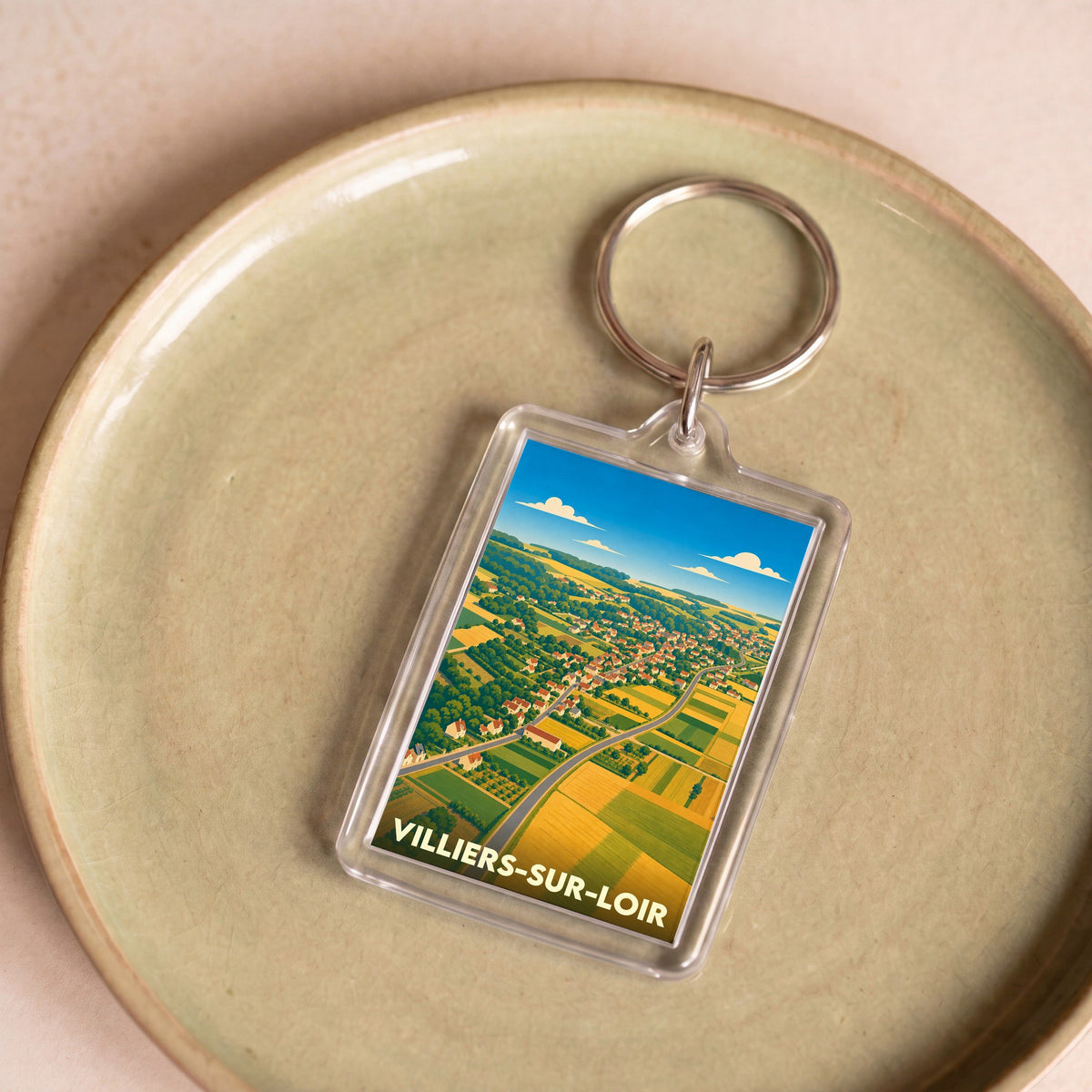 Porte-clés souvenir de la ville de Villiers-sur-Loir avec une illustration stylisée de ses paysages.