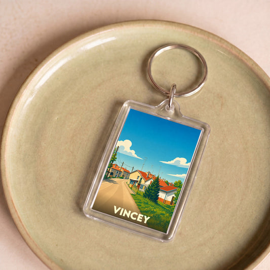 Porte-clés souvenir de la ville de Vincey avec une illustration stylisée.