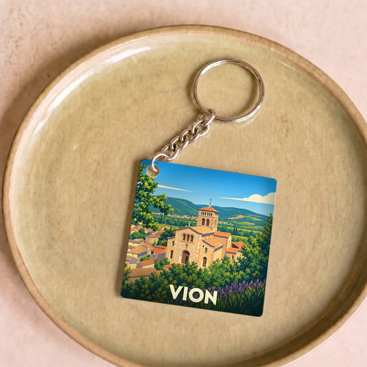 Porte-clés souvenir de la ville de Vion avec une illustration stylisée de son église et de son paysage.
