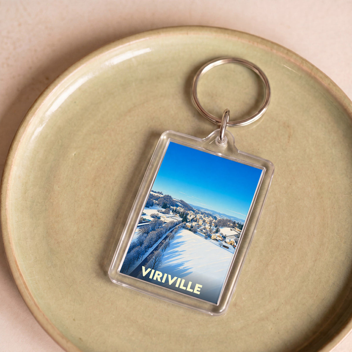 Porte-clés souvenir de la ville de Viriville illustré par un paysage hivernal enneigé.