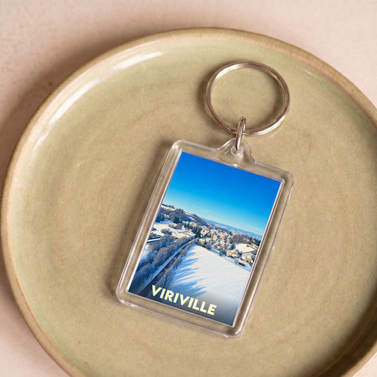 Porte-clés souvenir de la ville de Viriville illustré par un paysage hivernal enneigé.