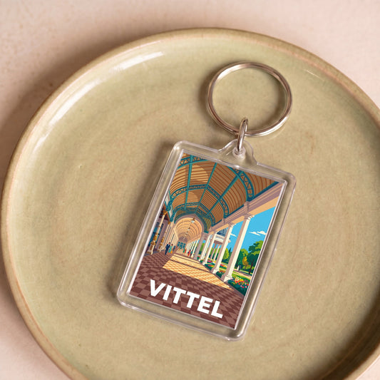 Porte-clés souvenir de la ville de Vittel avec une illustration stylisée.