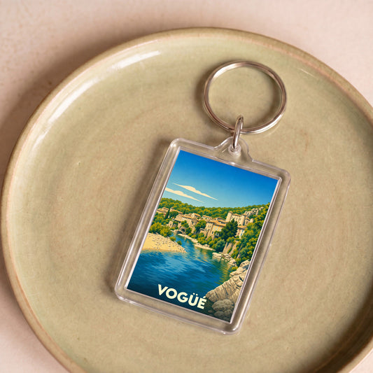 Porte-clés souvenir de la ville de Vogüé avec une illustration stylisée.