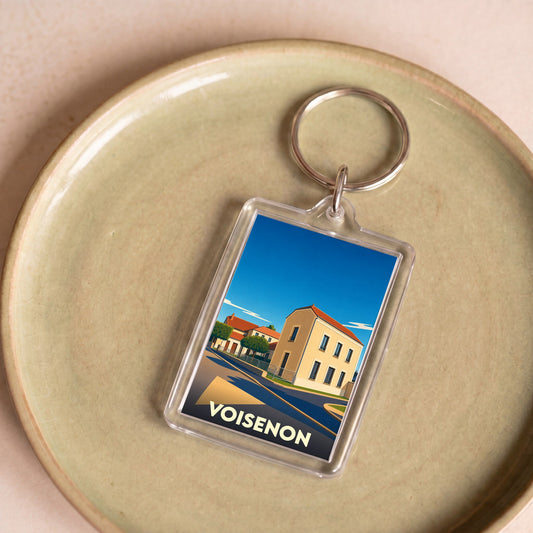 Porte-clés souvenir de la ville de Voisenon avec une illustration stylisée.