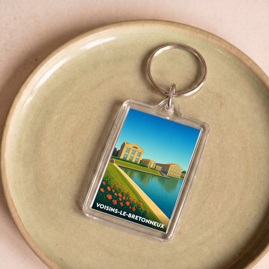 Porte-clés souvenir de la ville de Voisins-le-Bretonneux avec une illustration stylisée.
