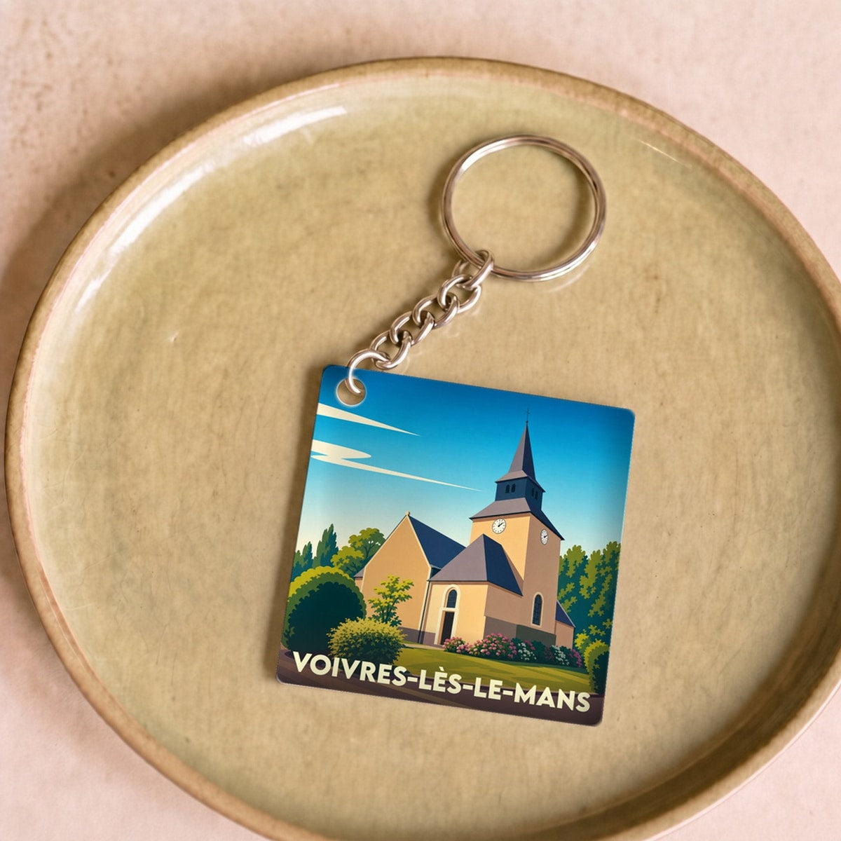 Porte-clés souvenir de la ville de Voivres-lès-le-Mans avec une illustration stylisée de son église.