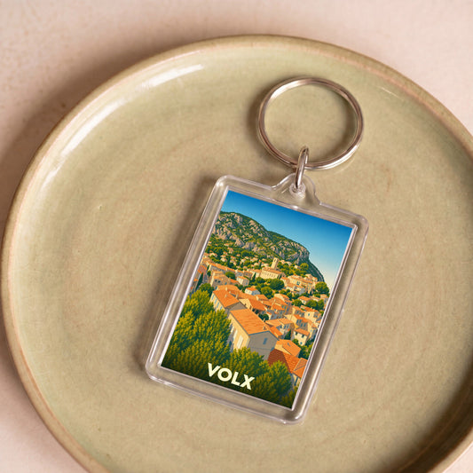 Porte-clés souvenir de la ville de Volx avec une illustration stylisée de ses paysages provençaux.