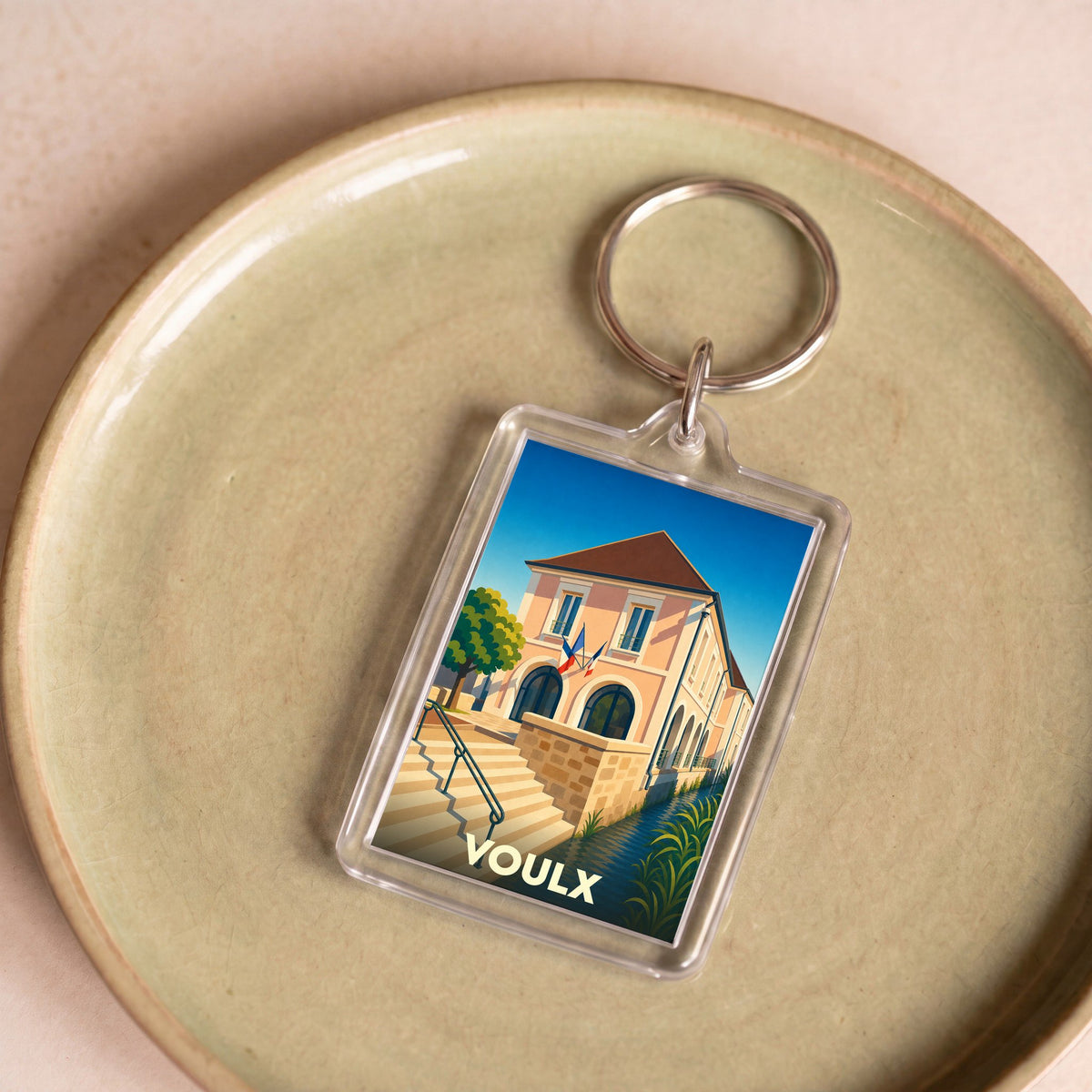 Porte-clés souvenir de la ville de Voulx avec une illustration stylisée de sa mairie.