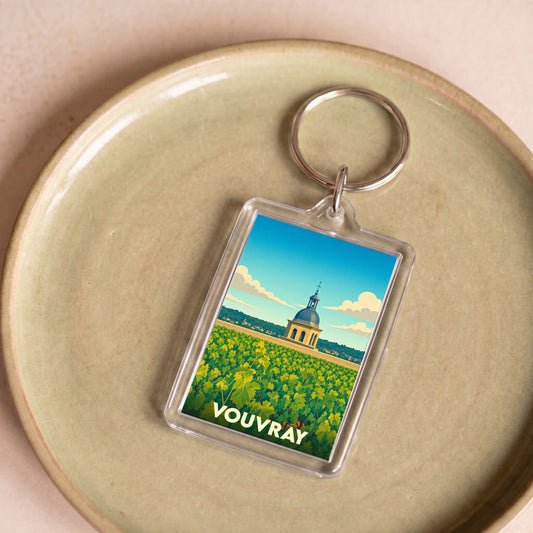 Porte-clés souvenir de la ville de Vouvray avec une illustration stylisée d'un vignoble et d'un monument historique.
