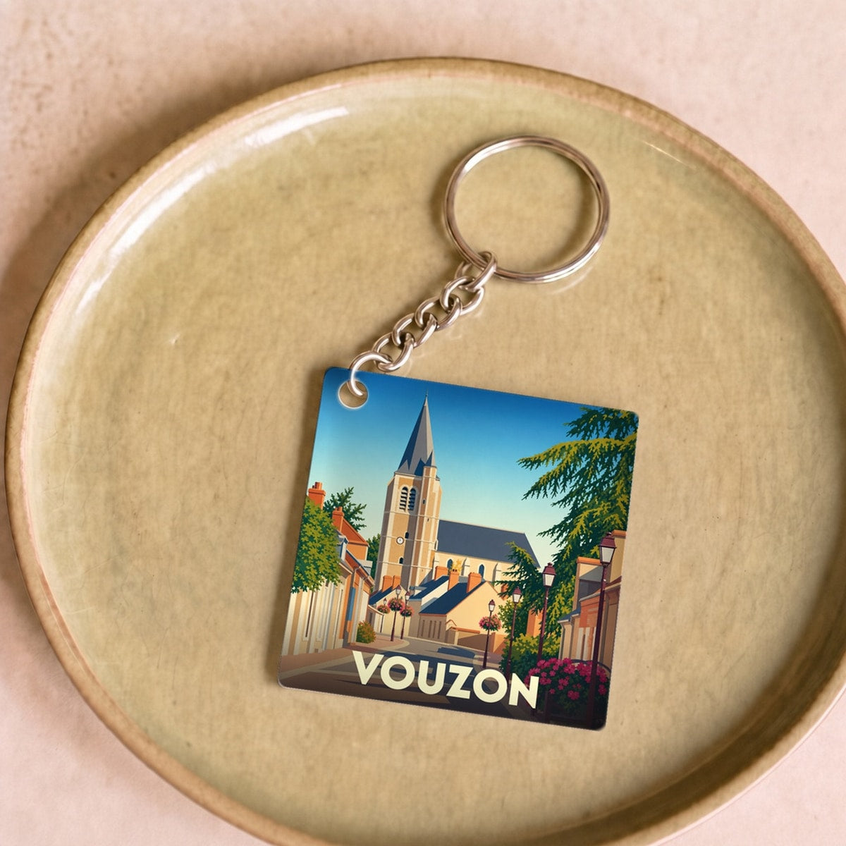 Porte-clés souvenir de la ville de Vouzon avec une illustration stylisée.