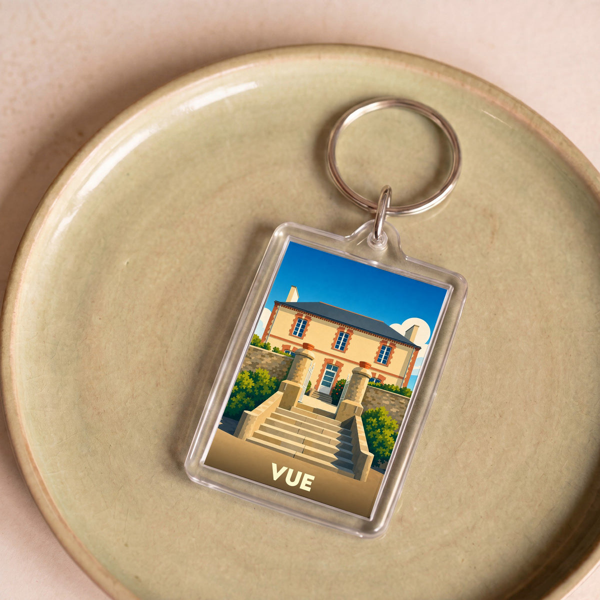 Porte-clés souvenir de la ville de Vue avec une illustration stylisée d'une maison de maître.