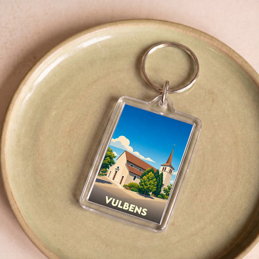 Porte-clés souvenir de la ville de Vulbens avec une illustration stylisée de son église.