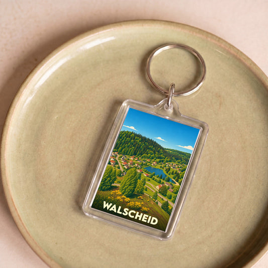 Porte-clés souvenir de la ville de Walscheid avec une illustration stylisée d'un paysage naturel.