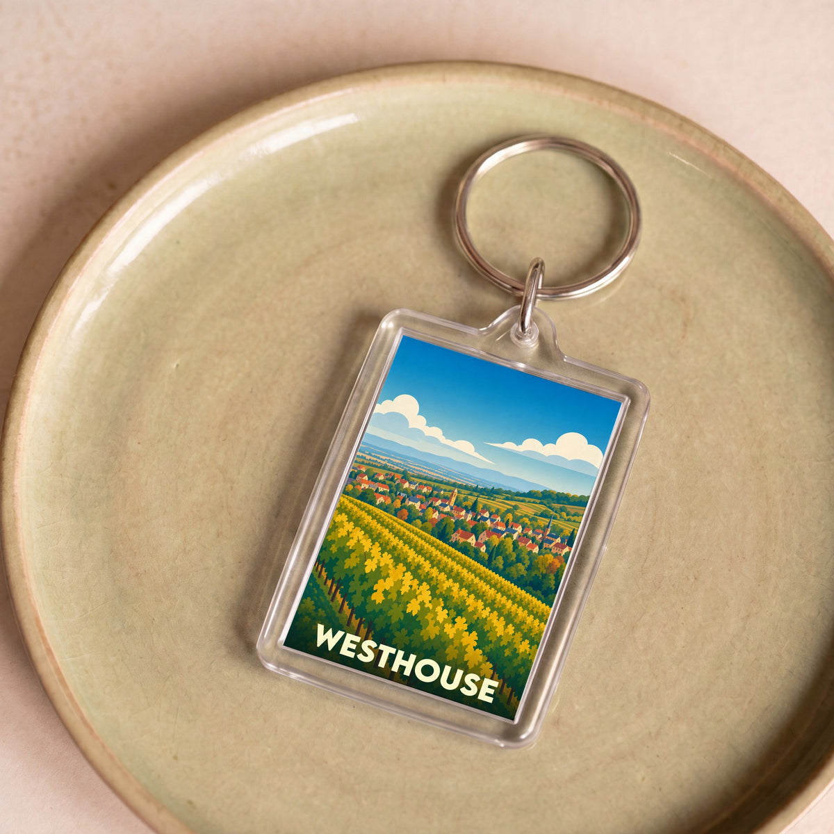 Porte-clés souvenir de la ville de Westhouse avec une illustration stylisée de son paysage.