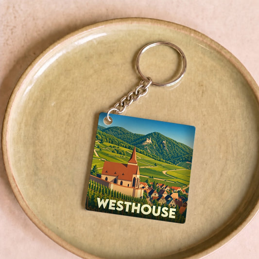 Porte-clés souvenir de la ville de Westhouse avec une illustration stylisée de son église et de ses vignobles.