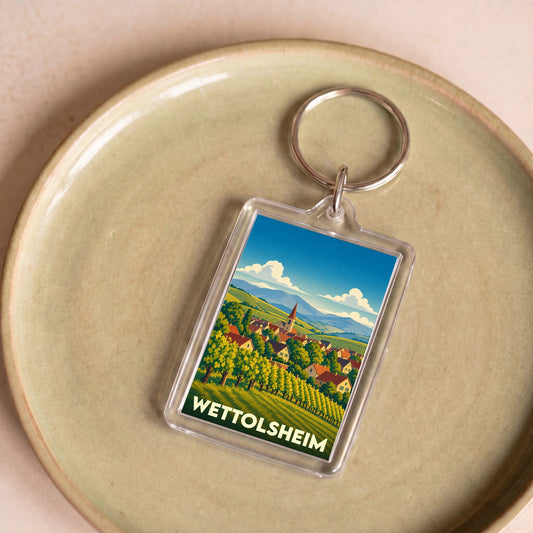 Porte-clés souvenir de la ville de Wettolsheim avec une illustration stylisée de son paysage de vignobles.